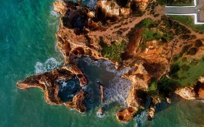 Aerial view of Ponta da Piedade's ochre rock formations and hidden coves surrounded by deep blue sea
