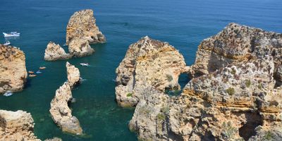 Golden limestone sea stacks and arches rising from turquoise waters at Ponta da Piedade