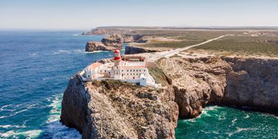 Cape St. Vincent cliffs dropping 75 metres into the Atlantic, with the lighthouse visible on the headland
