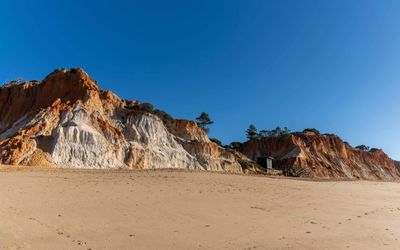 Natural erosion pillars and gullies in the sandstone cliffs at Praia da Falésia