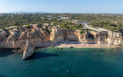 Looking down through green-tinged water to the sandy bottom at Praia da Marinha