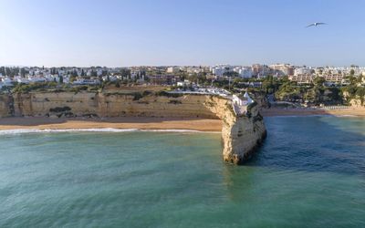 Aerial view from the sea showing the chapel headland dividing two golden beaches, with Porches town in the background