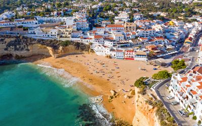 Aerial view of Carvoeiro village and beach surrounded by dramatic limestone cliffs
