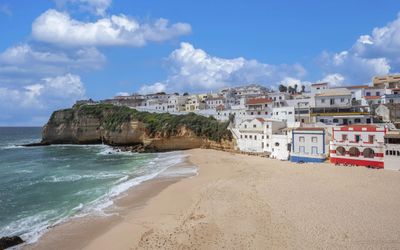 The crescent of golden sand at Praia do Carvoeiro framed by impressive cliff formations