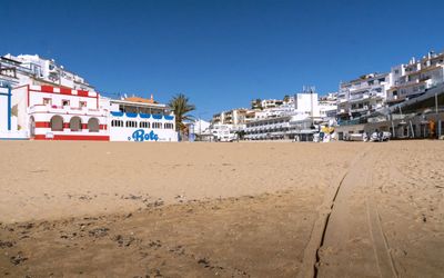 Whitewashed houses of Carvoeiro village tumbling down to the beach