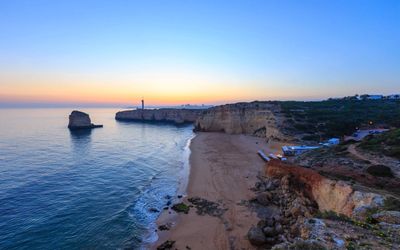 Praia dos Caneiros golden sand beach with ochre cliffs and turquoise water