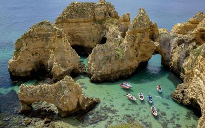 Boats in the turquoise waters among towering rock formations at Ponta da Piedade