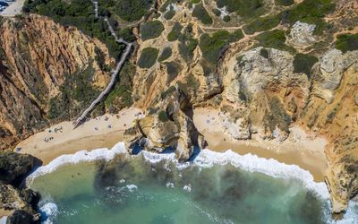 Aerial view of Praia do Camilo's turquoise waters and sheltered cove