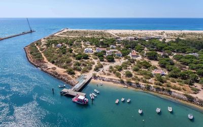 Wooden pier leading to Praia da Ilha de Tavira across the lagoon