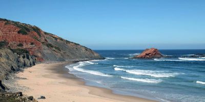 Praia da Ponta Ruiva with its distinctive red-tinged cliffs facing the Atlantic