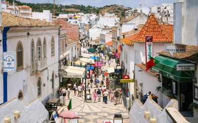 Narrow cobbled street lined with whitewashed buildings and traditional restaurants in Albufeira's old town
