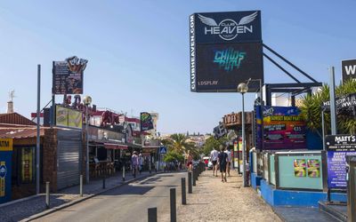 Neon-lit bars and restaurants along Albufeira's famous Strip at night