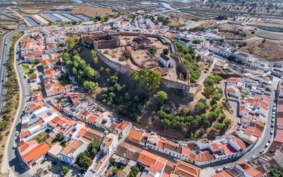 Aerial view of Castro Marim Castle surrounded by the whitewashed town with salt pans visible in the background
