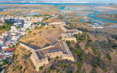 Aerial view of the star-shaped Forte de São Sebastião with the town and salt marshes of the Guadiana estuary beyond