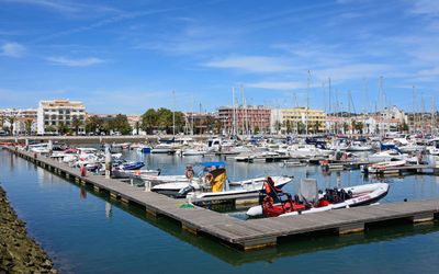 Boats moored in the modern Marina de Lagos with promenade and shops