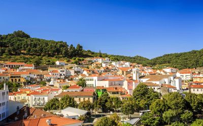 Whitewashed hillside houses in Monchique set among green mountains