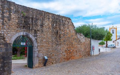 Stone entrance archway to Tavira Castle with medieval walls and battlements