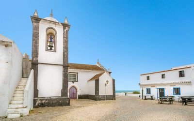 The 18th-century church of Cacela Velha with its whitewashed walls against the blue sky