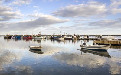 Traditional fishing boats in Santa Luzia harbour with octopus pots on the quayside